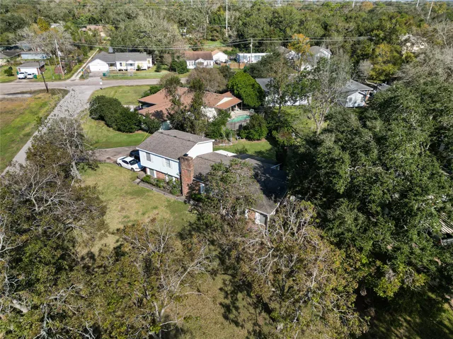 an aerial view of residential houses with outdoor space and trees