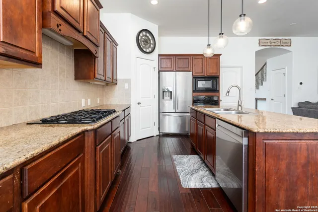 a kitchen with granite countertop stainless steel appliances and wooden cabinets