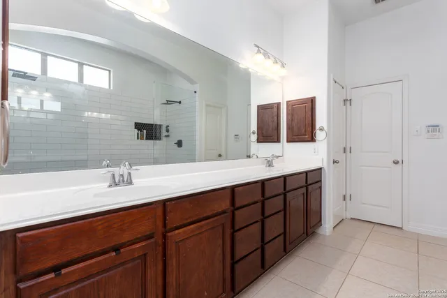 a bathroom with double vanity sinks and a large mirror
