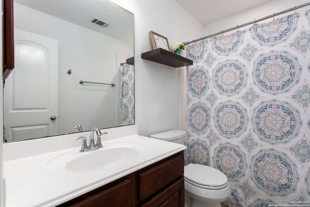 a bathroom with a toilet sink and mirror