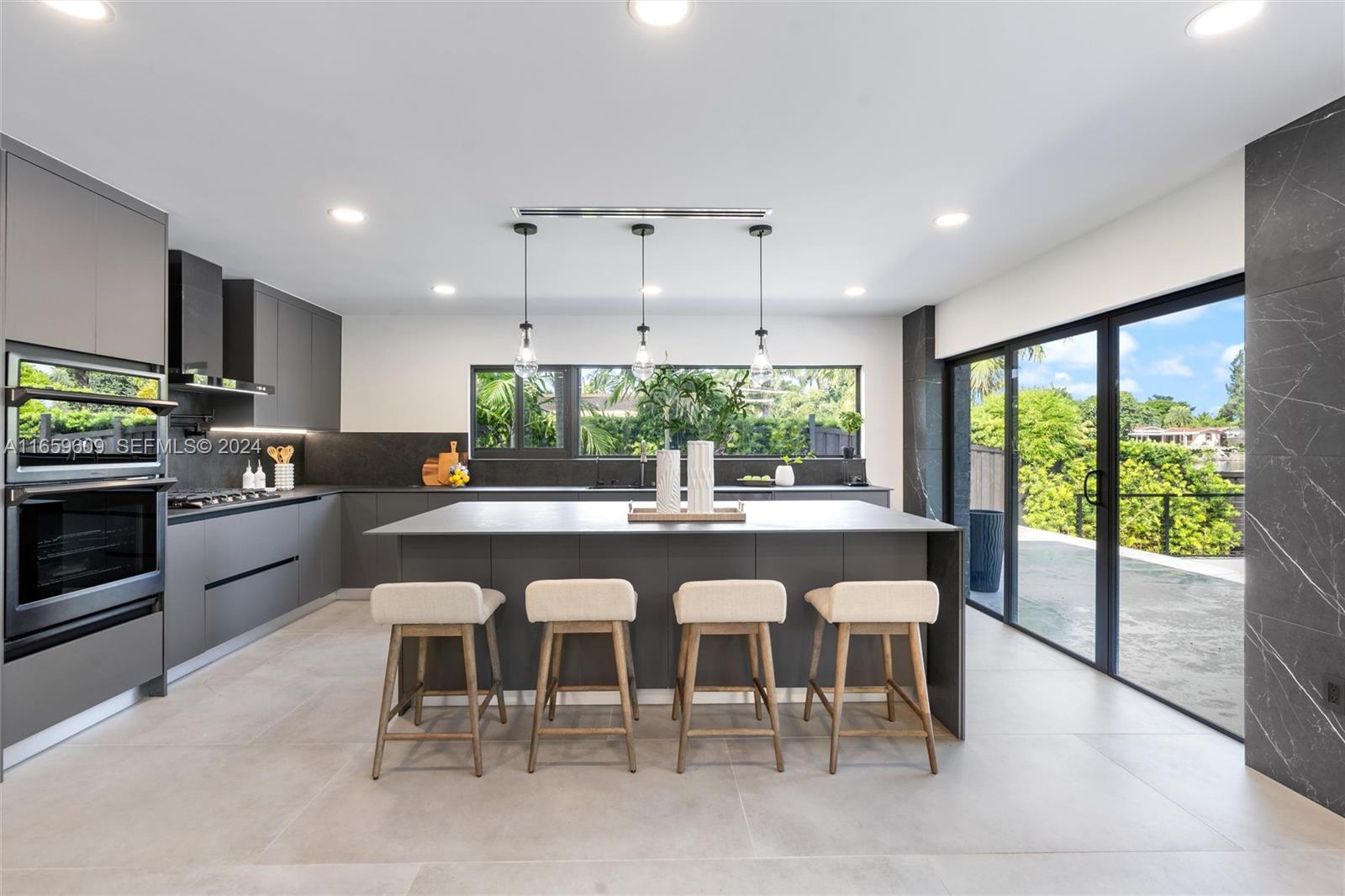 2261 Northeast 192 Street Miami, FL 33180 - Photo 12 of 24 a large kitchen with a table and chairs