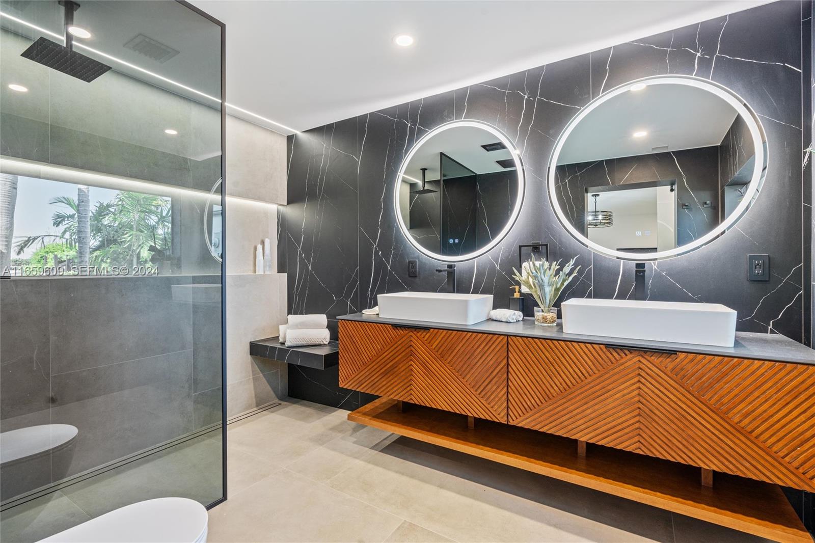 2261 Northeast 192 Street Miami, FL 33180 - Photo 18 of 24 a bathroom with a toilet a sink and a mirror