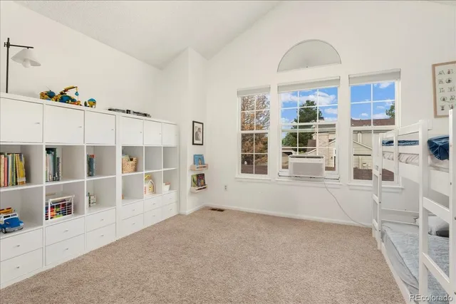 a view of an empty room with window and hardwood