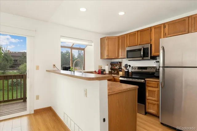 a kitchen with a sink a microwave a refrigerator and wooden cabinets