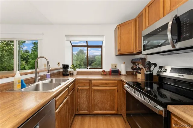 a kitchen with a sink stove top oven and cabinets
