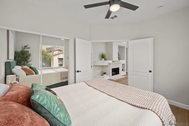 a bedroom with a large bed and ceiling fan