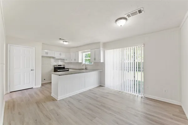 a kitchen with wooden floors and white appliances