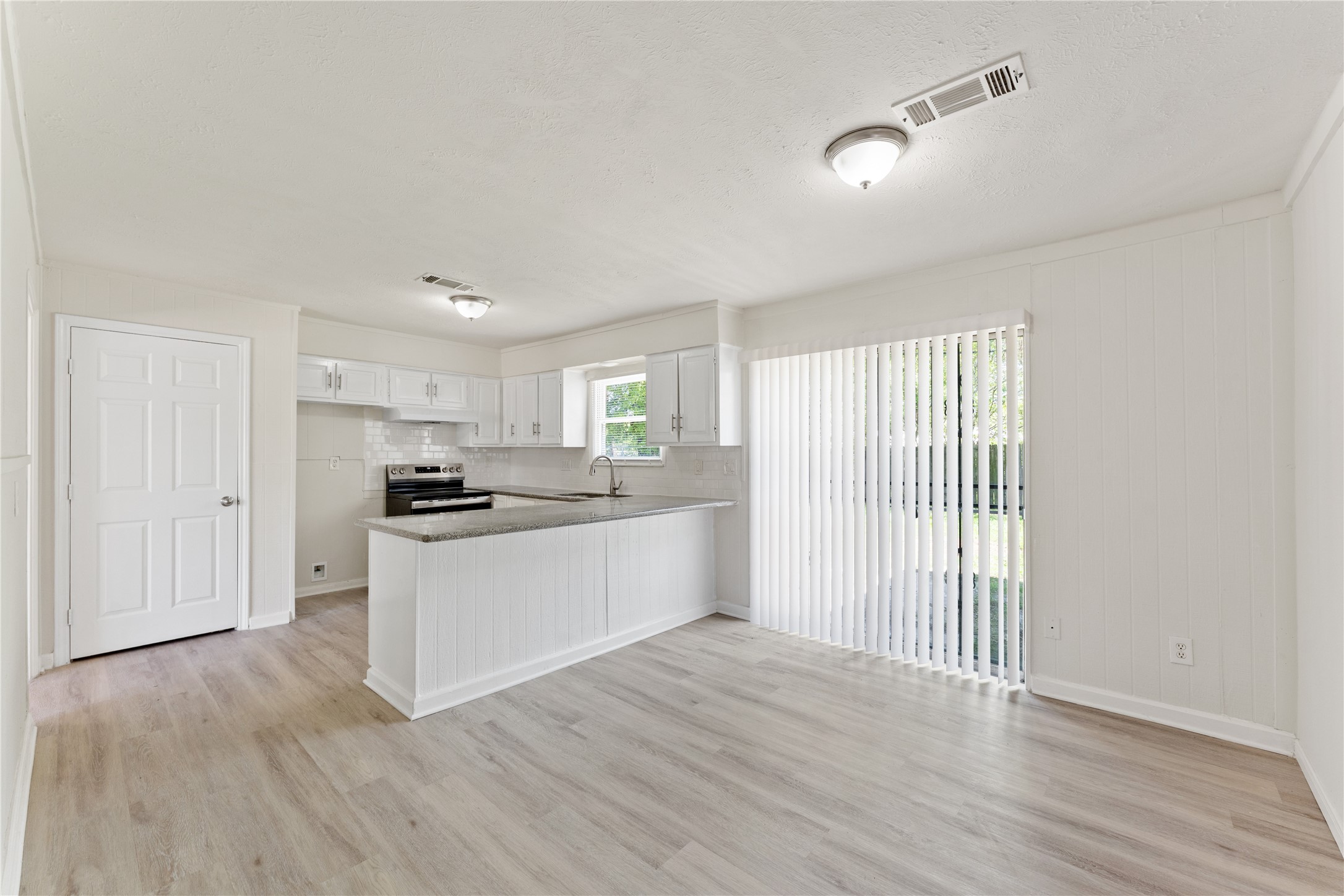 7725 St Lo Road Houston, TX 77033 - Photo 11 of 26 a kitchen with wooden floors and white appliances