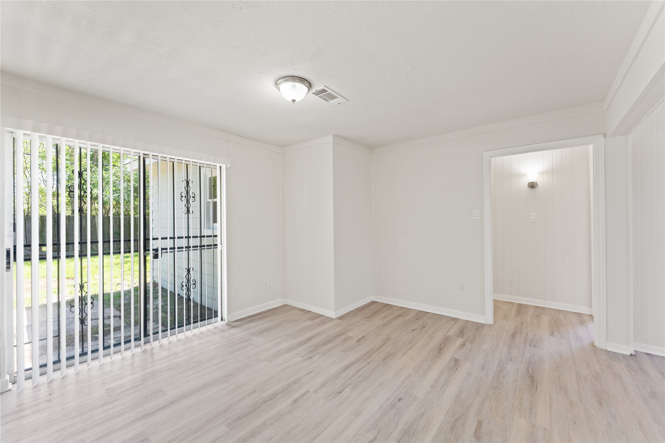 7725 St Lo Road Houston, TX 77033 - Photo 12 of 26 an empty room with wooden floor and windows