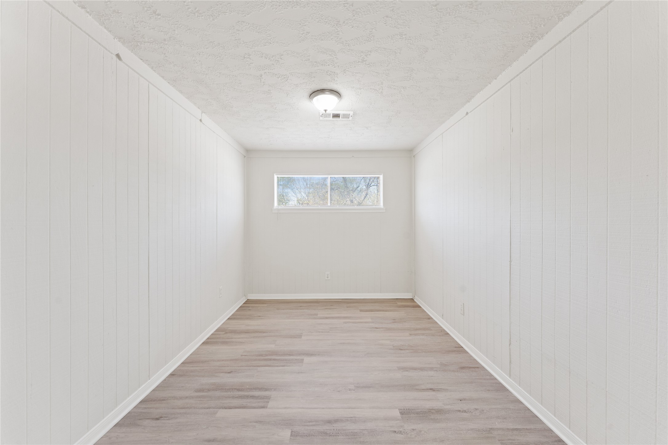 7725 St Lo Road Houston, TX 77033 - Photo 13 of 26 a view of an empty room with wooden floor and a window