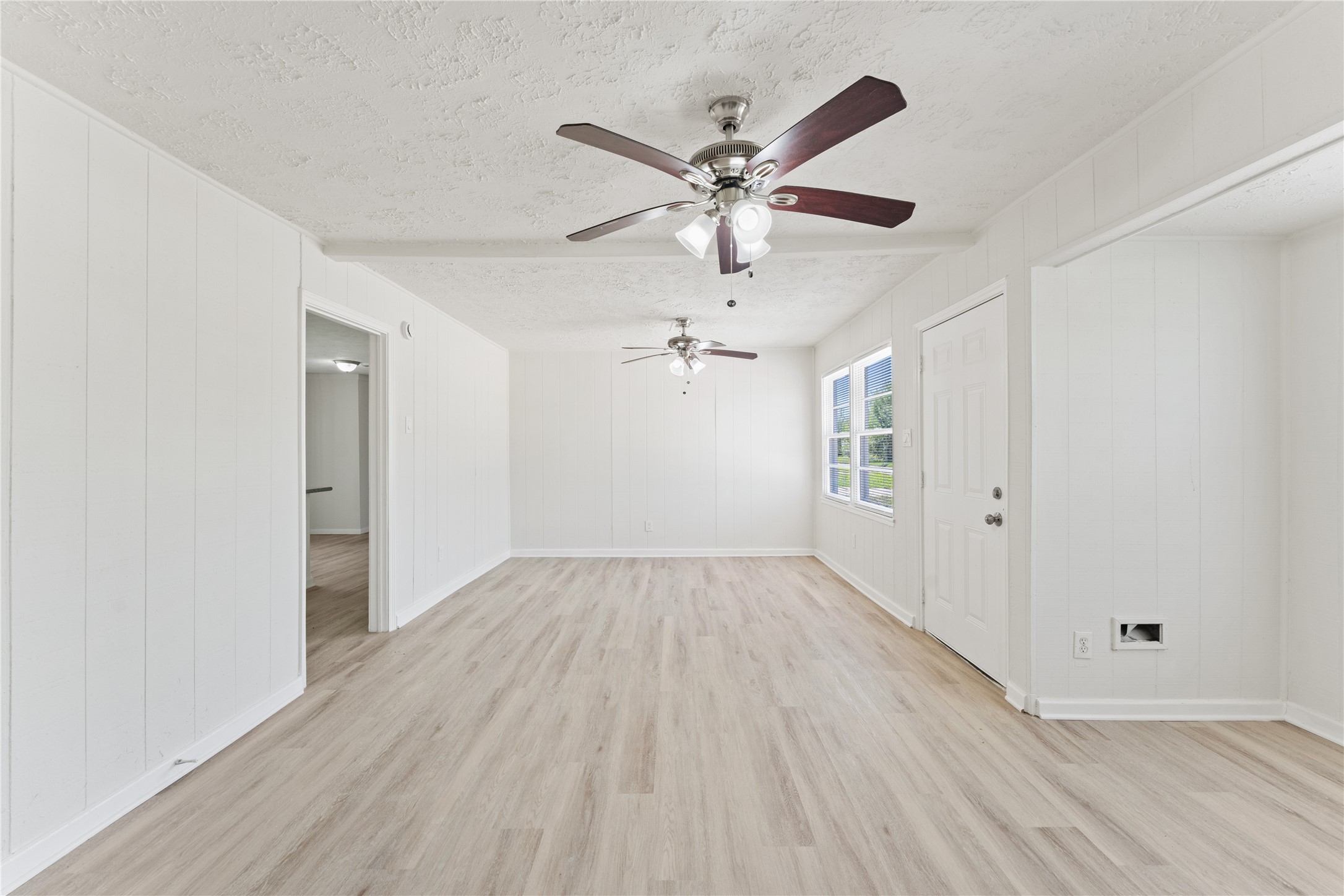 7725 St Lo Road Houston, TX 77033 - Photo 7 of 26 an empty room with wooden floor fan and windows