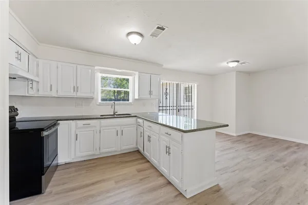 a kitchen with granite countertop a stove and a sink