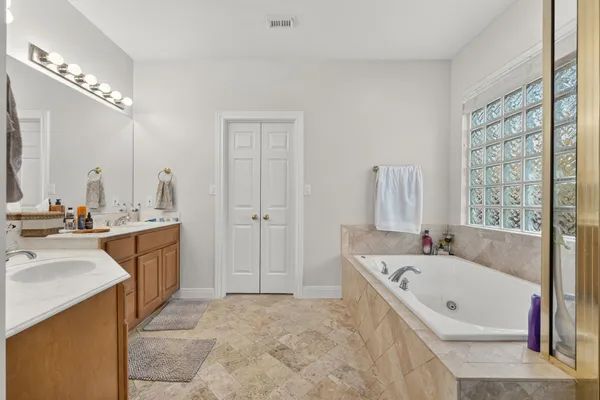 a bathroom with a tub sink and mirror