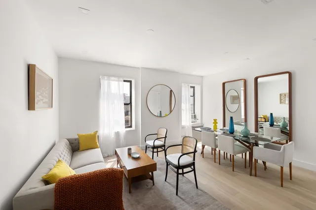 a living room with furniture a large window and wooden floor