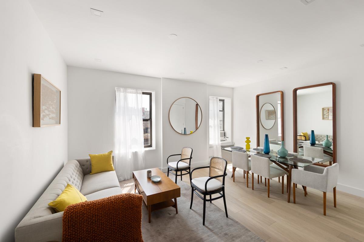 a living room with furniture a large window and wooden floor