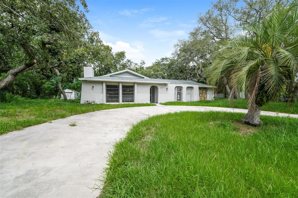 2009 Meadow Lark Road Spring Hill, FL 34608 - Photo 1 of 1 a front view of a house with a garden
