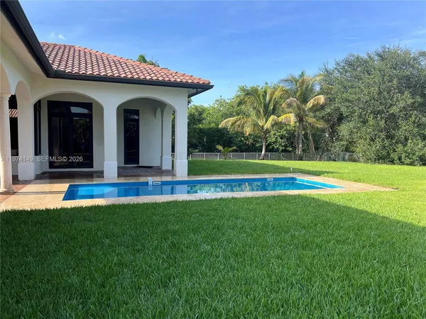 a view of a house with swimming pool and a yard