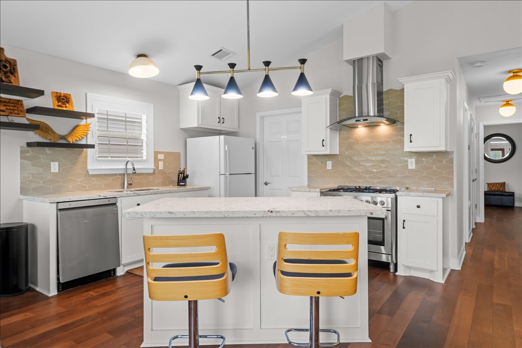 608 Whistleville Road Flatonia, TX 78941 - Photo 3 of 26 The kitchen has a fantastic center island that’s perfect for casual breakfast seating, beautiful granite countertops, and a modern, stylish light fixture that really anchors the space.