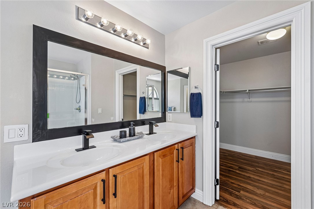 1176 Butternut Ranch Court Henderson, NV 89052 - Photo 35 of 60 Double vanity with sleek modern fixtures and rich cabinetry define this practical and pleasant bathroom space.