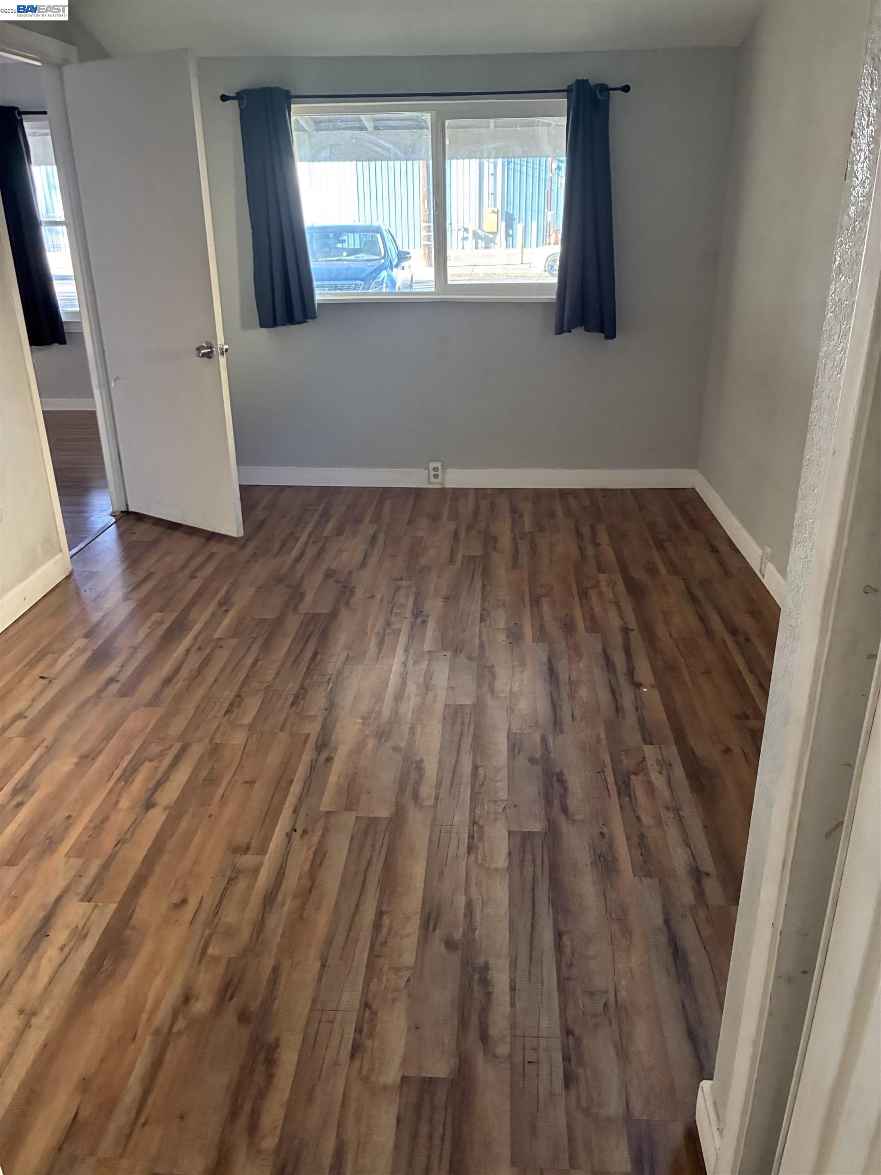 1614 Mono Drive Modesto, CA 95354 - Photo 9 of 15 an empty room with wooden floor and windows