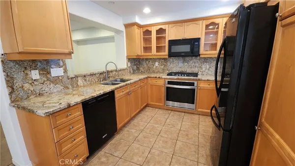 a kitchen with stainless steel appliances granite countertop a stove sink and cabinets
