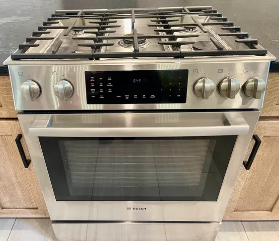 a view of an empty room with wooden floor and a ceiling fan