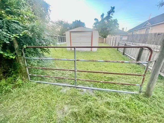a view of a house with backyard and trees