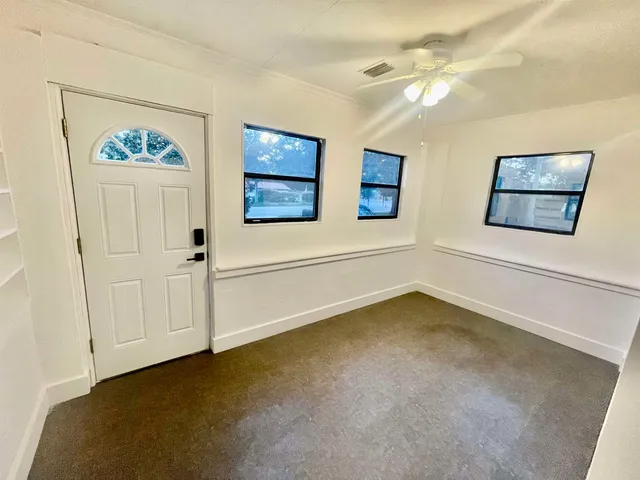 a view of empty room with wooden floor