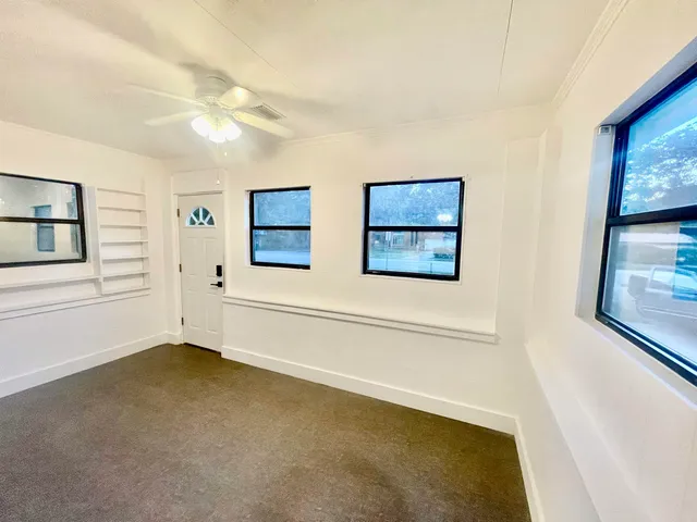 a view of a kitchen with wooden floor and a ceiling fan