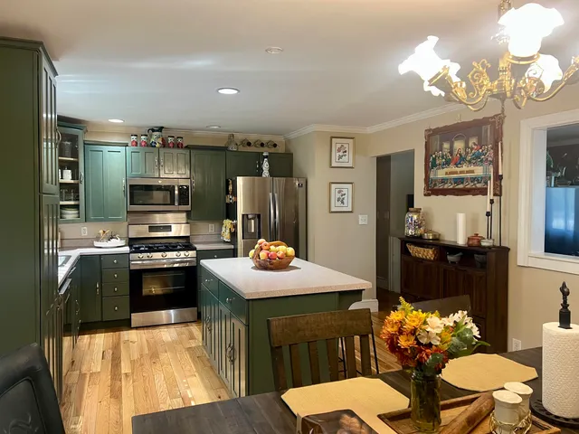 a dining room with furniture a chandelier and wooden floor