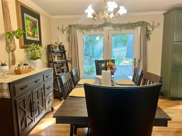 a view of a dining room with furniture a chandelier and wooden floor