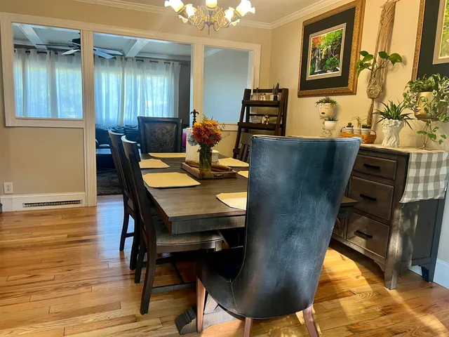 a kitchen with stainless steel appliances wooden floor dining table and chairs