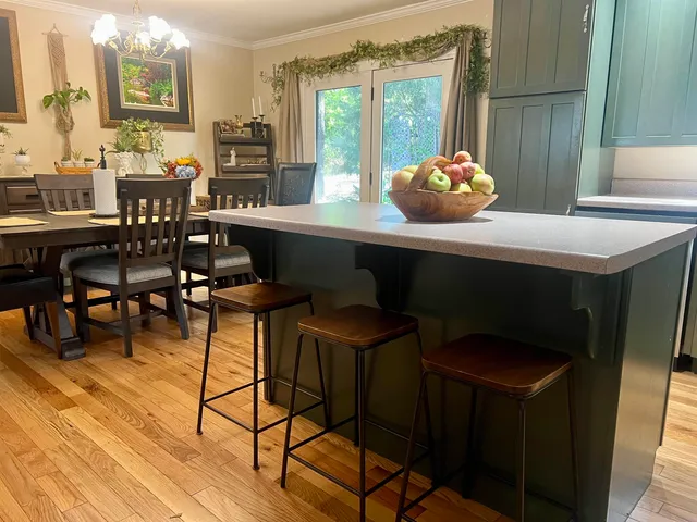 a kitchen with stainless steel appliances kitchen island granite countertop a sink dishwasher stove and refrigerator with wooden floor