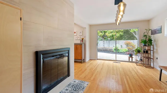 a view of empty room with wooden floor and fireplace