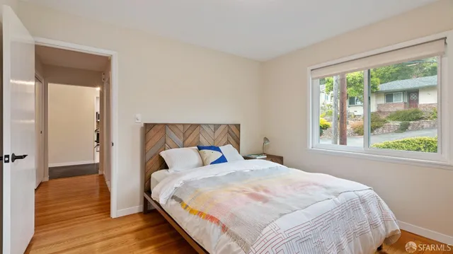 a bedroom with a bed and wooden floor