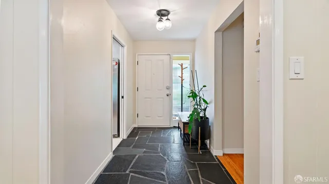 a view of a hallway with wooden floor and a potted plant