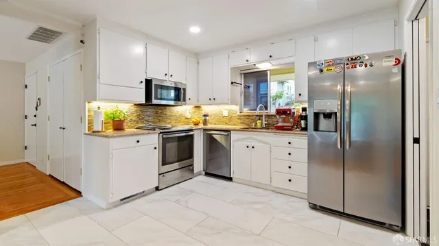 a kitchen with stainless steel appliances a refrigerator sink and cabinets