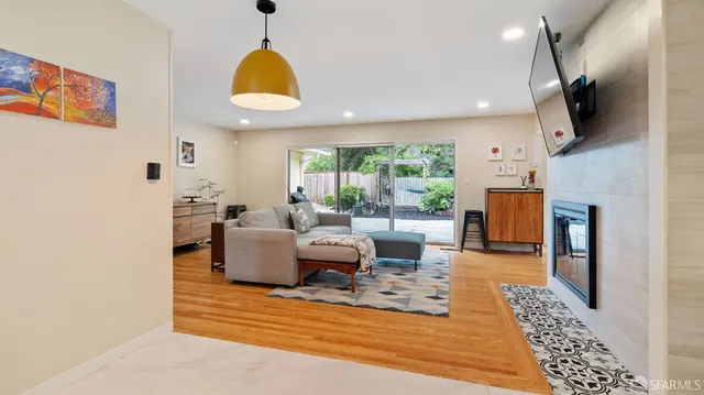 a living room with fireplace furniture and a large window
