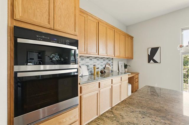 a kitchen with stainless steel appliances granite countertop white cabinets and a stove