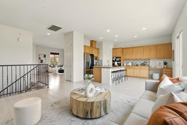 a living room with furniture kitchen and a large window