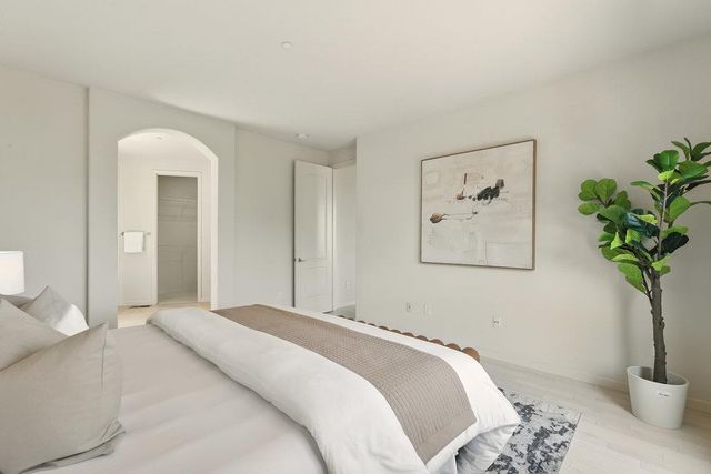 a bedroom with a bed and a potted plant