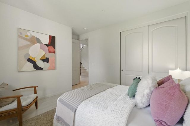 a bedroom with a bed and a painting on the wall