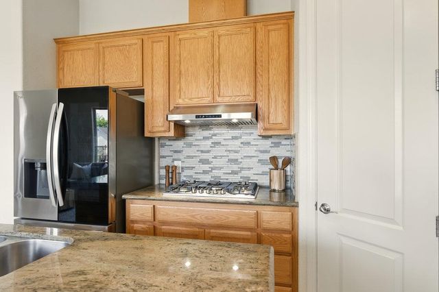 a kitchen with stainless steel appliances granite countertop a refrigerator and a sink