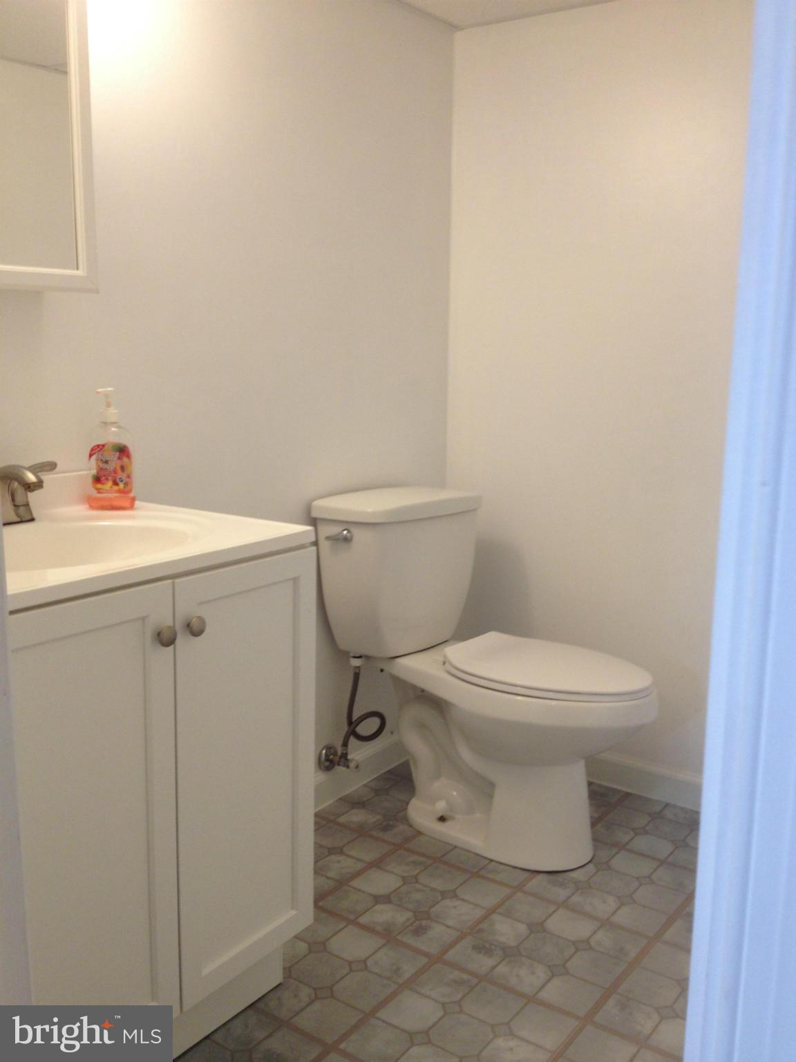 8513 Water Oak Road Baltimore, MD 21234 - Photo 22 of 27 a white toilet sitting next to a white sink and vanity