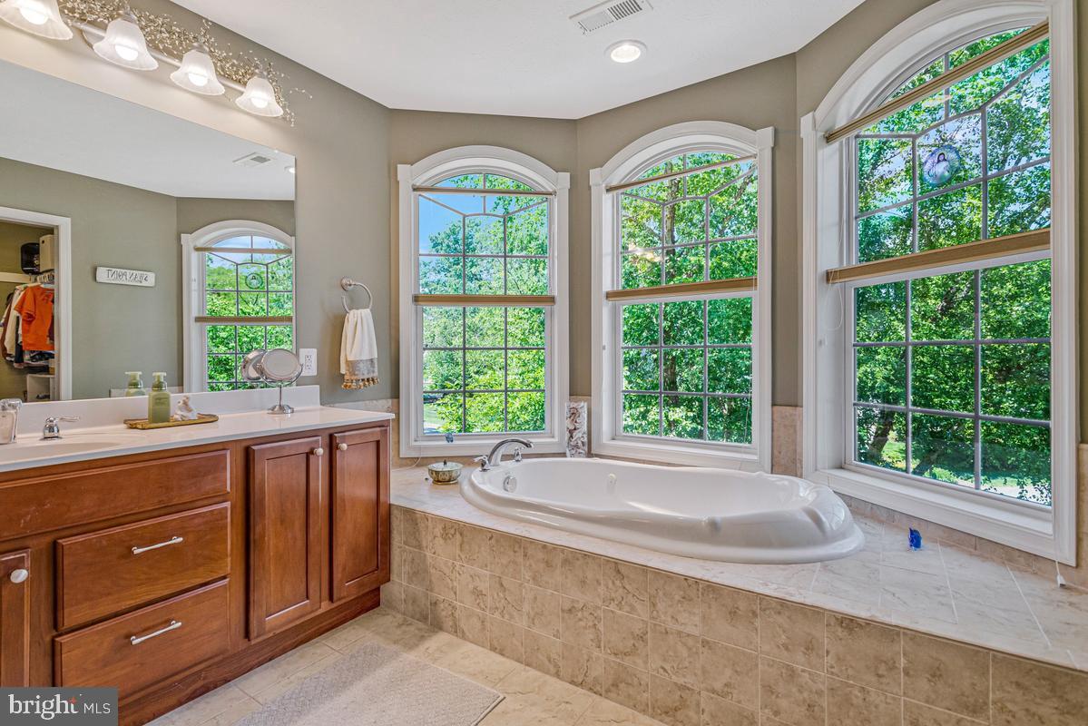 11565 Magnolia Court Issue, MD 20645 - Photo 32 of 68 a spacious bathroom with a tub a sink and large window