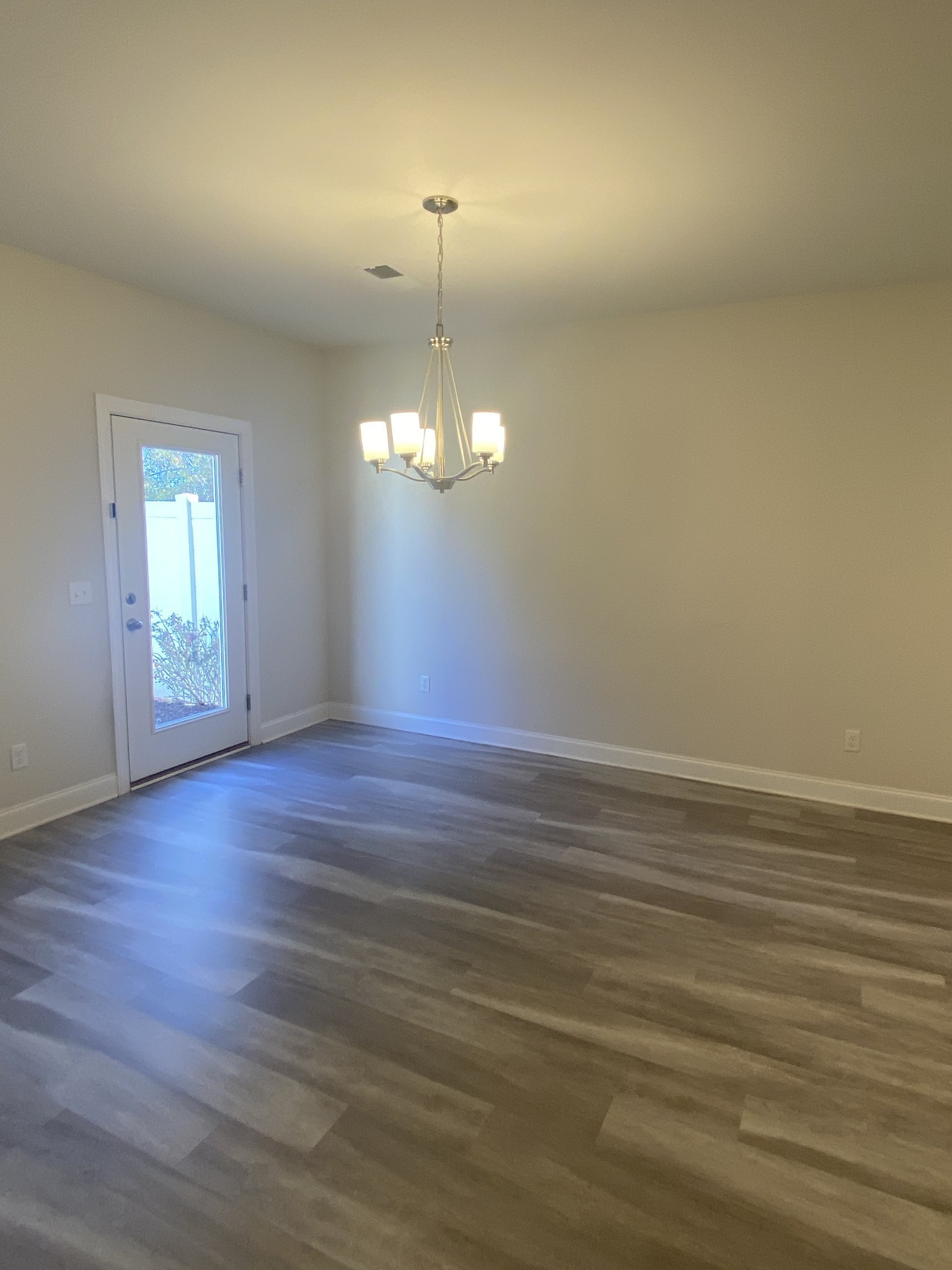 1364 Vilda Way Lebanon, TN 37087 - Photo 7 of 18 an empty room with wooden floor chandelier and windows