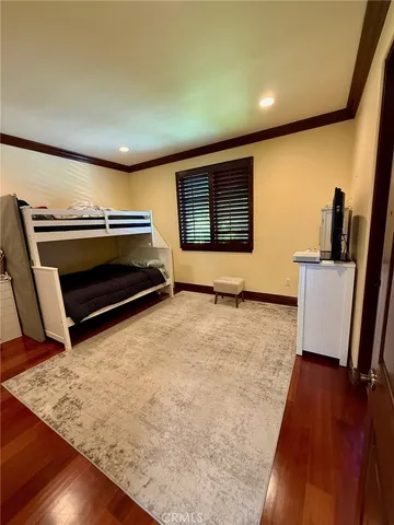 a bedroom with furniture and a wooden floor