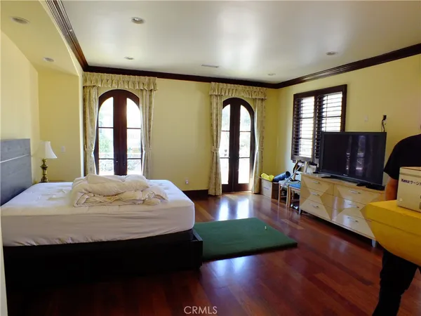 a spacious bedroom with a bed and wooden floor