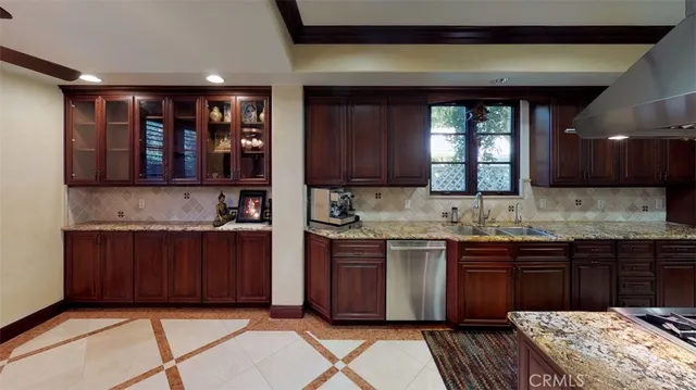 a kitchen with stainless steel appliances granite countertop wooden cabinets a sink and dishwasher