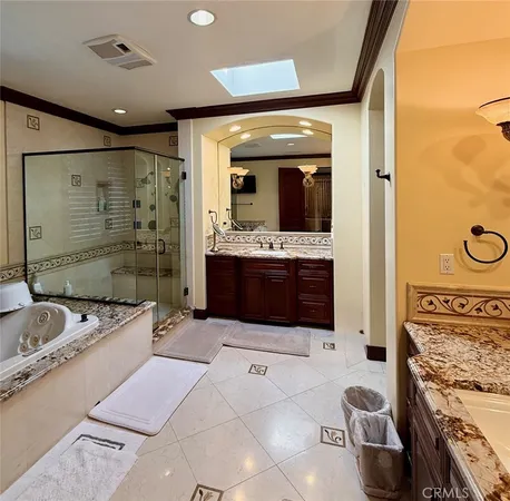a spacious bathroom with a granite countertop sink mirror and bathtub